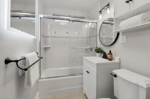 a bathroom with a granite countertop sink a mirror and a shower