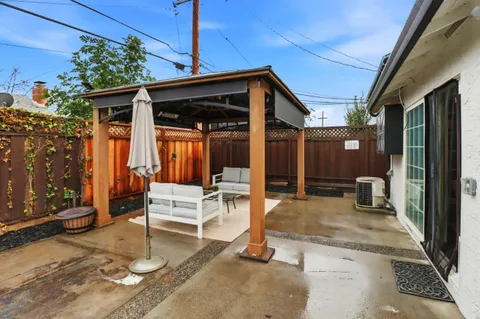 a view of a patio with table and chairs potted plants with wooden floor and fence