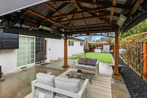 a backyard of a house with yard table and chairs