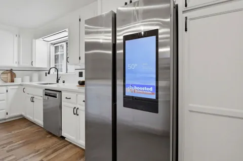 a kitchen with a refrigerator sink and cabinets
