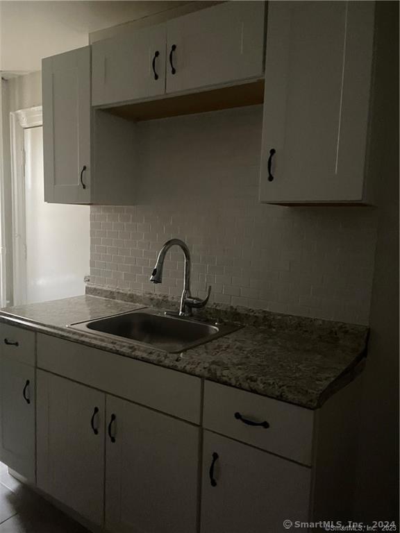 a sink with granite countertop cabinets