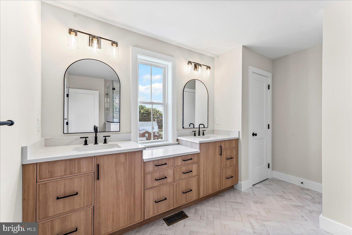 738 South Matlack Street West Chester, PA 19382 - Photo 15 of 23 a bathroom with a double vanity sink a mirror and a bathtub