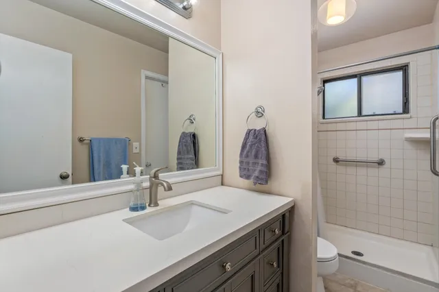 a bathroom with a granite countertop sink toilet and shower