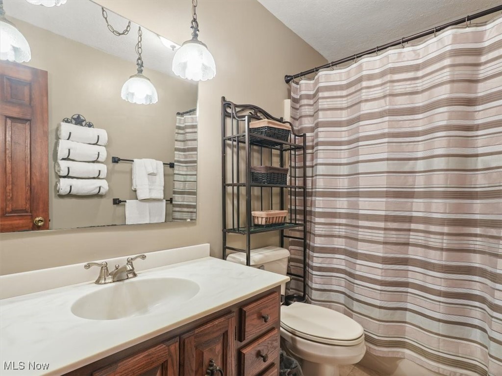 3098 East Union Road Jefferson, OH 44047 - Photo 13 of 44 Bathroom featuring a textured ceiling, vanity, toilet, and a shower/Tub
