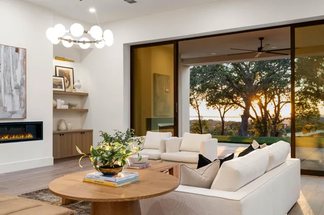 a living room with fireplace furniture and a large window