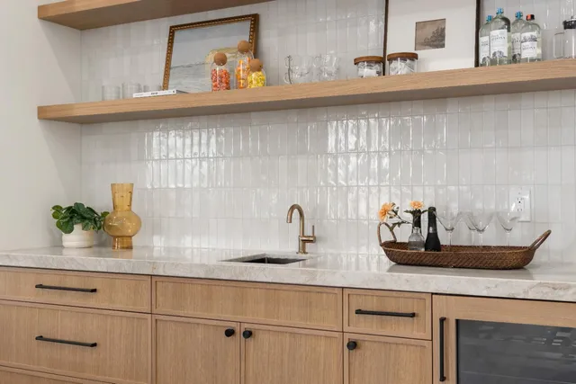 a living room with furniture kitchen view and large windows