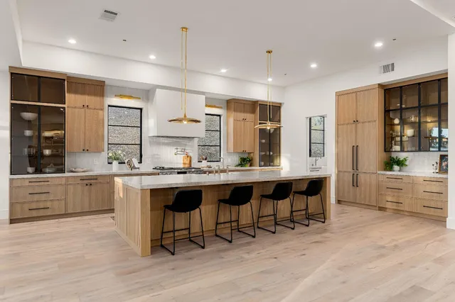 a kitchen with white cabinets and a window
