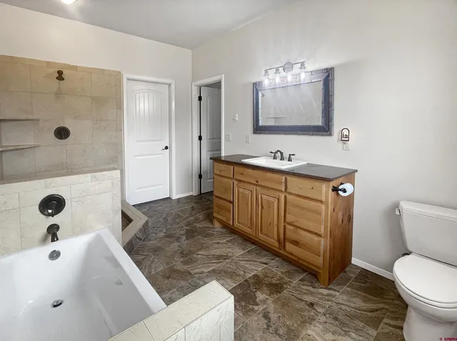 a bathroom with a sink a toilet and mirror