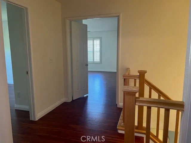 a view of a hallway with wooden floor and stairs