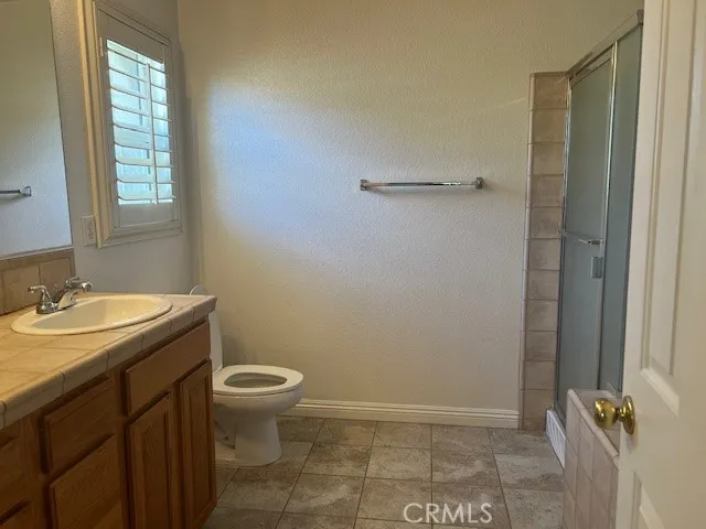 a bathroom with a granite countertop sink a toilet and a mirror