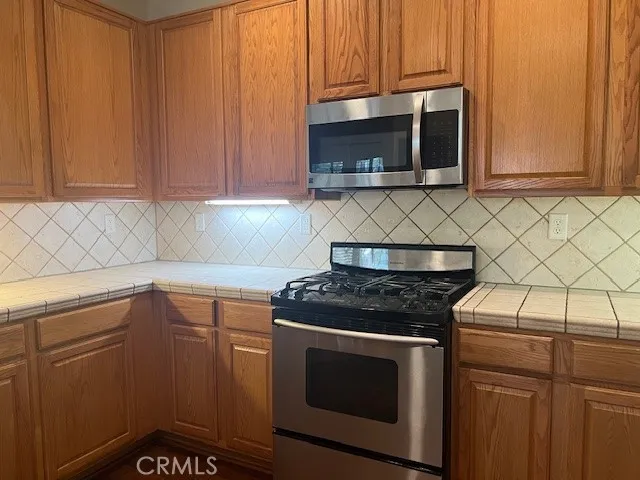 a kitchen with granite countertop white cabinets and stainless steel appliances