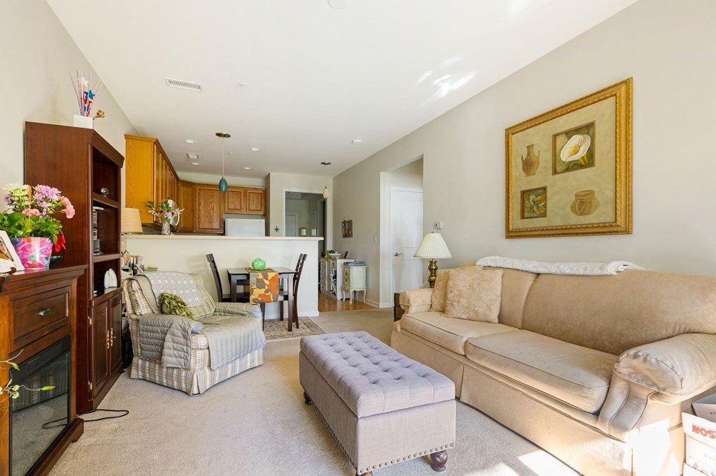 107 Clocktower Drive, Unit 107 Waltham, MA 02452 - Photo 2 of 13 a living room with furniture and a couch