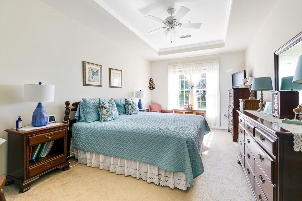 107 Clocktower Drive, Unit 107 Waltham, MA 02452 - Photo 5 of 13 a bedroom with a bed and a flat screen tv