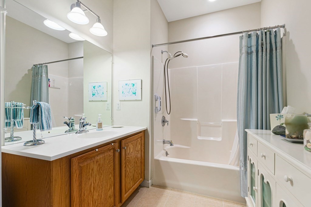107 Clocktower Drive, Unit 107 Waltham, MA 02452 - Photo 7 of 13 a bathroom with a bathtub shower sink vanity and a mirror