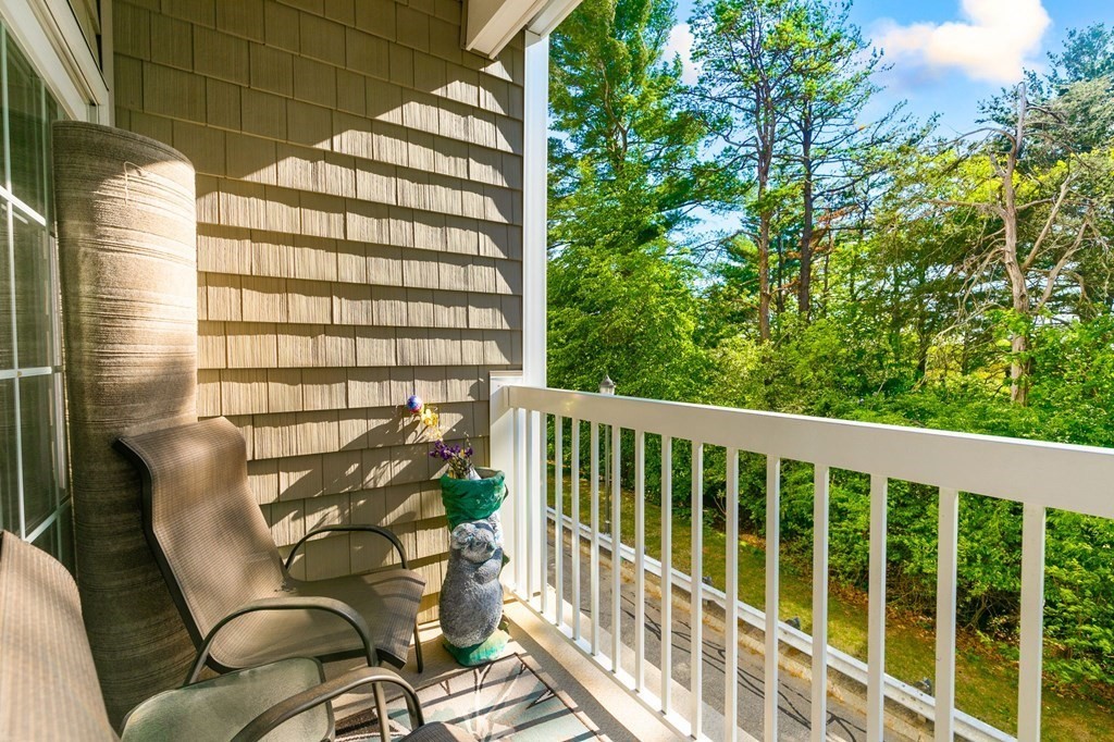 107 Clocktower Drive, Unit 107 Waltham, MA 02452 - Photo 8 of 13 a balcony with table and chairs