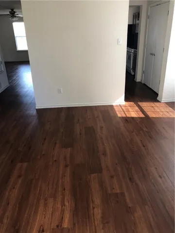 a view of a room with wooden floor and a window