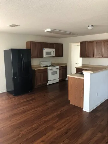 a kitchen with stainless steel appliances wooden floors and cabinets
