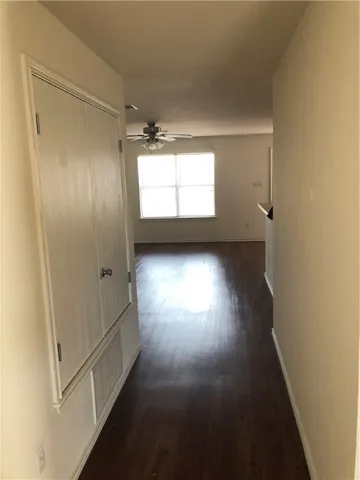 a view of empty room with wooden floor and windows