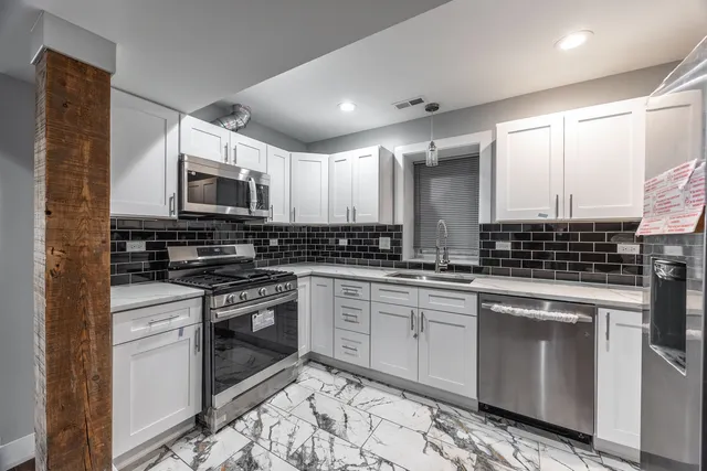 a kitchen with stainless steel appliances granite countertop a stove top oven a sink and a microwave