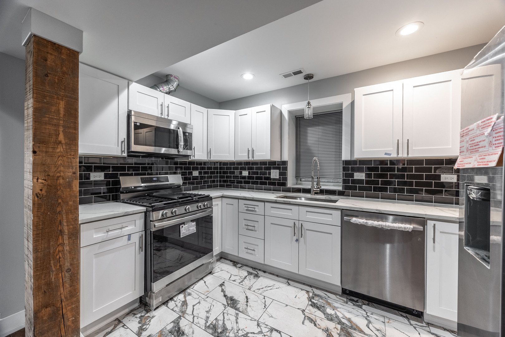 3328 West Congress Parkway, Unit G Chicago, IL 60624 - Photo 2 of 12 a kitchen with stainless steel appliances granite countertop a stove top oven a sink and a microwave