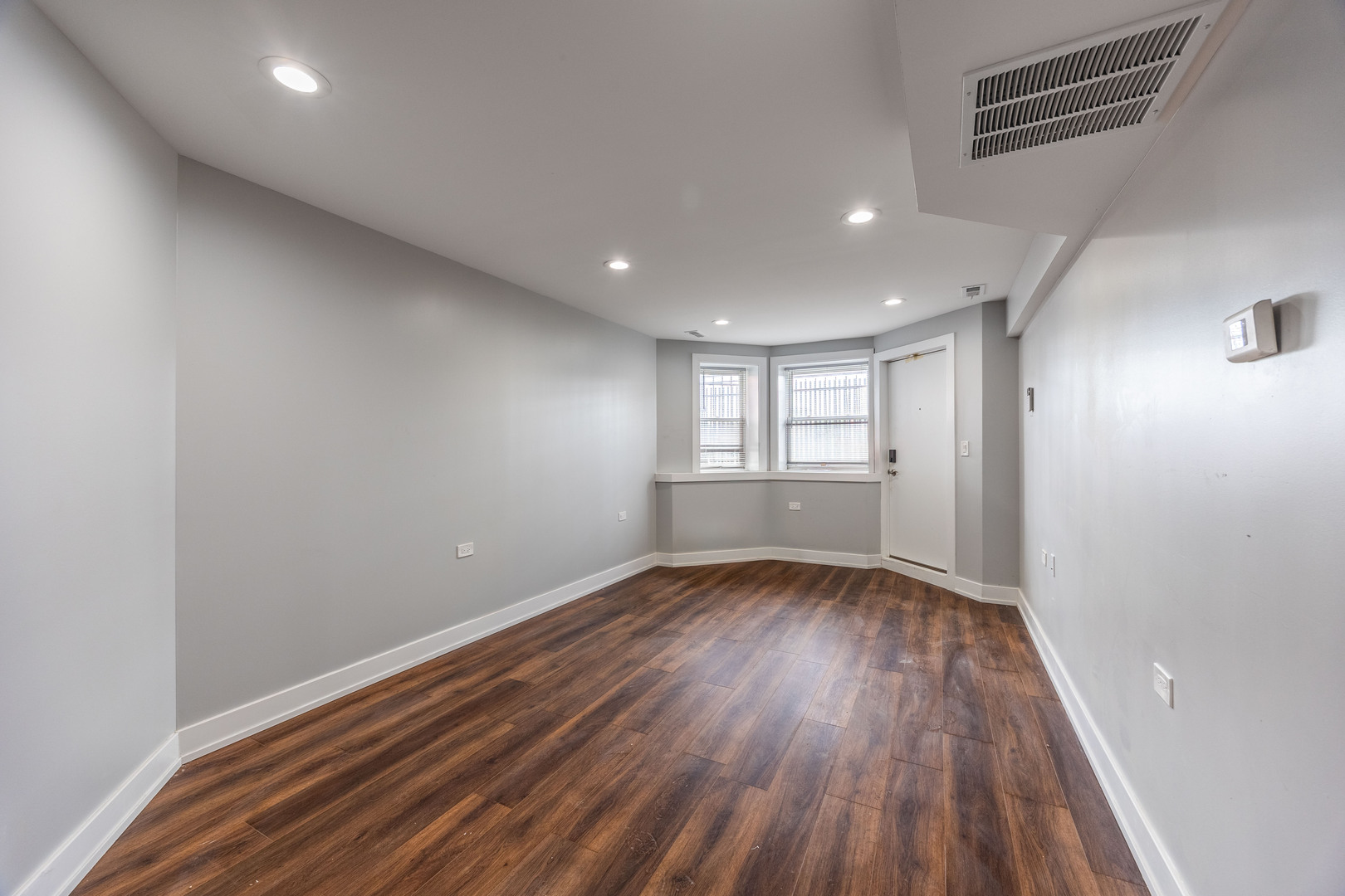 3328 West Congress Parkway, Unit G Chicago, IL 60624 - Photo 5 of 12 a view of an empty room with wooden floor and window