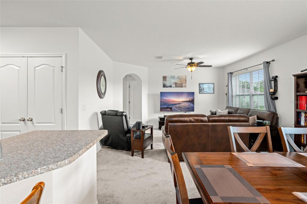 3449 Seneca Club Loop, Unit 24101 Orlando, FL 32808 - Photo 11 of 29 a living room with furniture a flat screen tv and a table