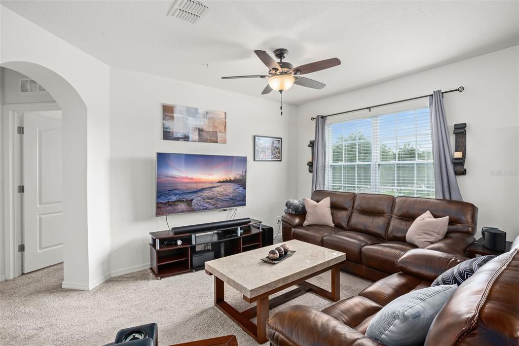 3449 Seneca Club Loop, Unit 24101 Orlando, FL 32808 - Photo 12 of 29 a living room with furniture a ceiling fan and a window