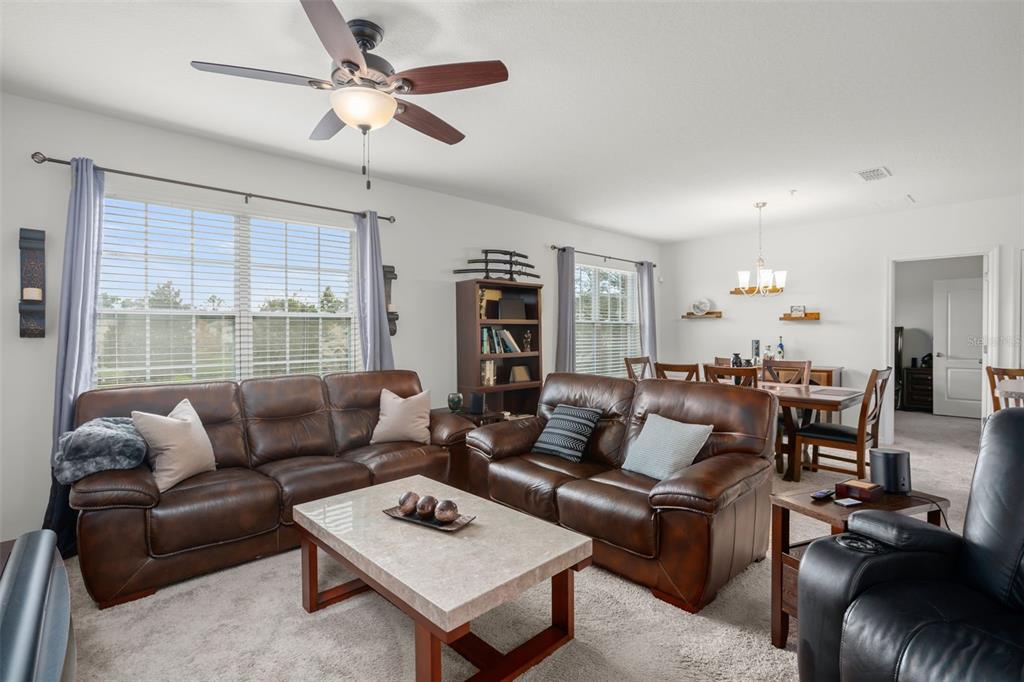 3449 Seneca Club Loop, Unit 24101 Orlando, FL 32808 - Photo 14 of 29 a living room with furniture ceiling fan and a window