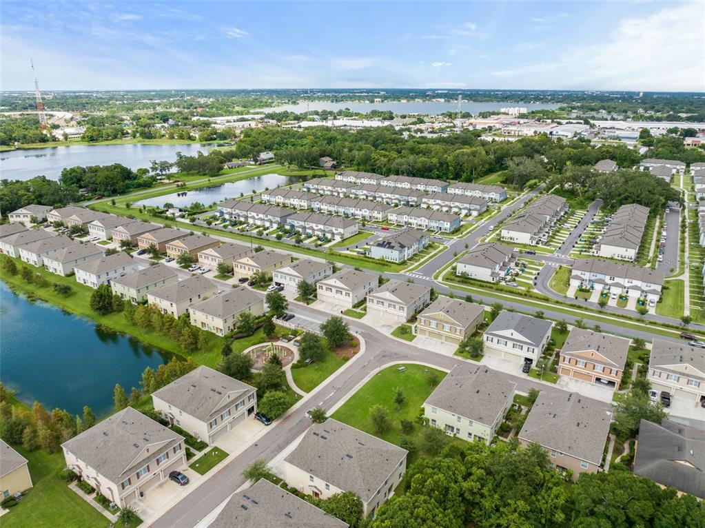 3449 Seneca Club Loop, Unit 24101 Orlando, FL 32808 - Photo 21 of 29 an aerial view of a city with lots of residential buildings ocean and mountain view in back
