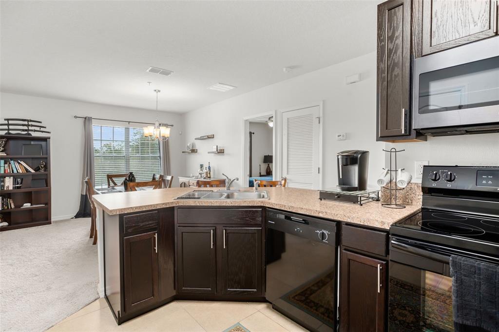 3449 Seneca Club Loop, Unit 24101 Orlando, FL 32808 - Photo 5 of 29 a kitchen with a sink stove and cabinets