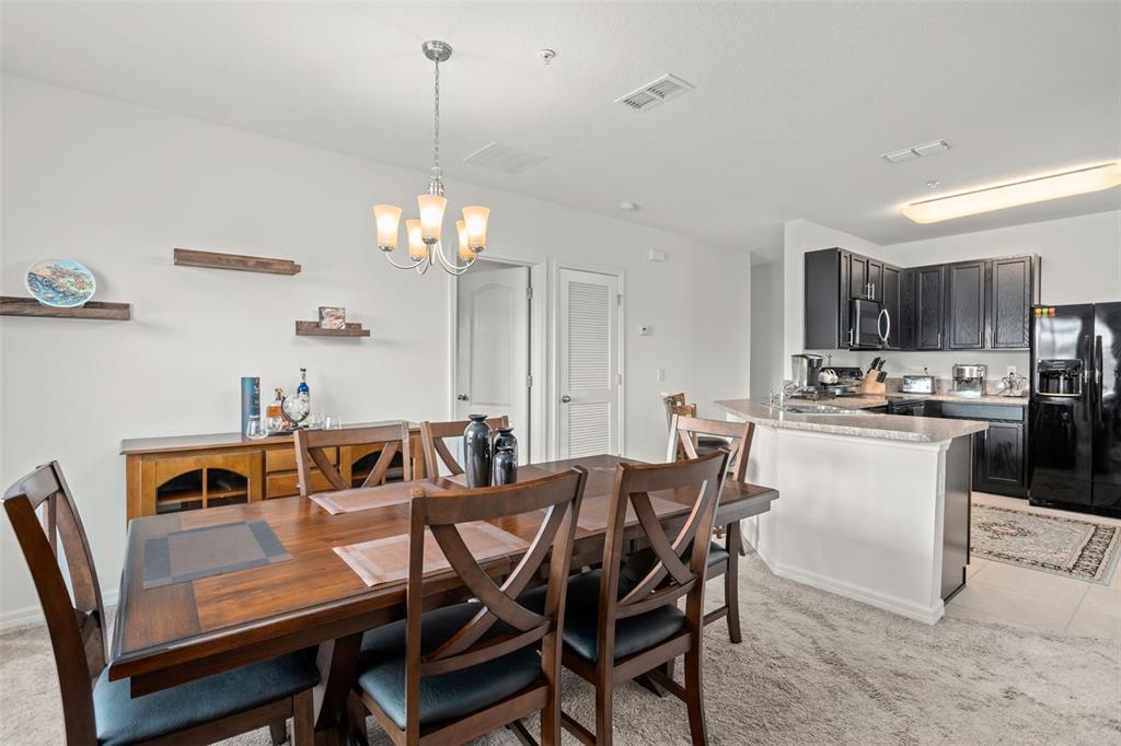 3449 Seneca Club Loop, Unit 24101 Orlando, FL 32808 - Photo 7 of 29 a view of a dining room with furniture and chandelier