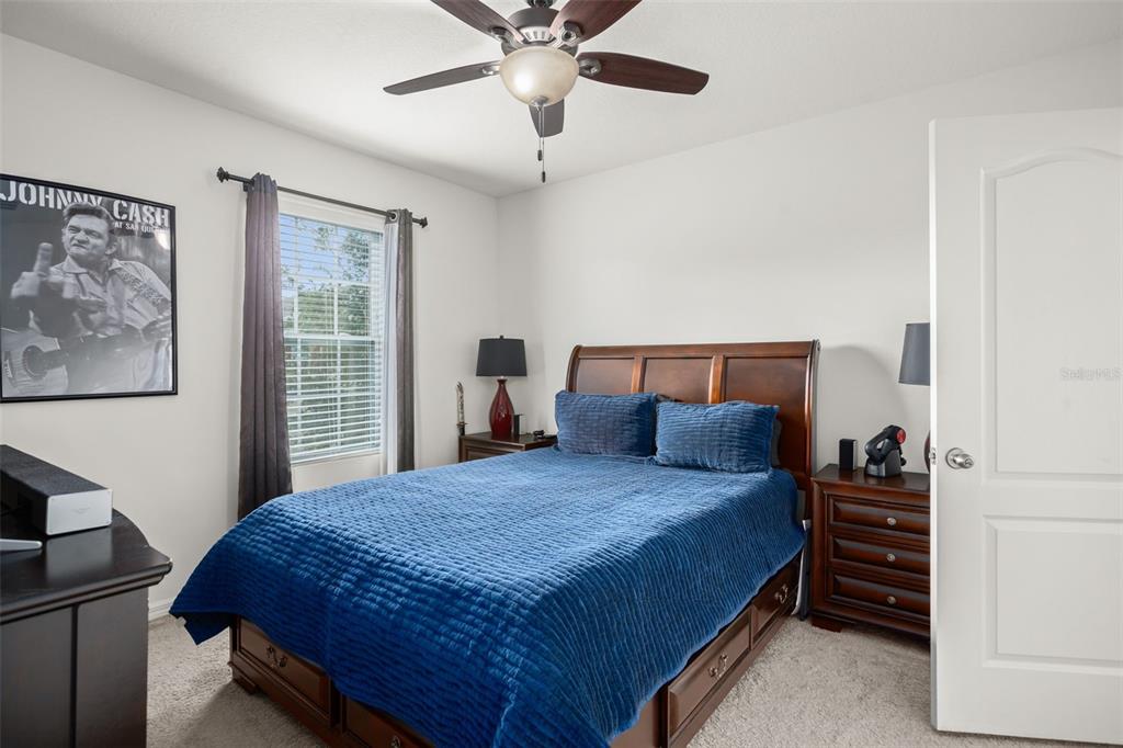 3449 Seneca Club Loop, Unit 24101 Orlando, FL 32808 - Photo 8 of 29 a bedroom with a bed and a chandelier