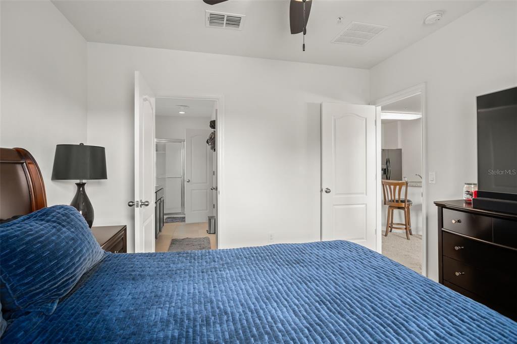 3449 Seneca Club Loop, Unit 24101 Orlando, FL 32808 - Photo 9 of 29 a bedroom with a bed and wooden floor