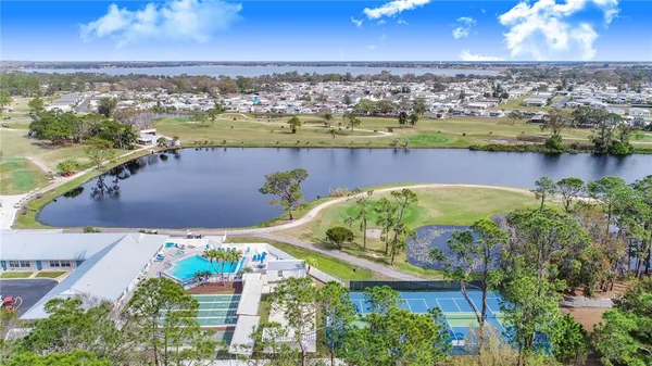 an aerial view of ocean and residential houses with outdoor space
