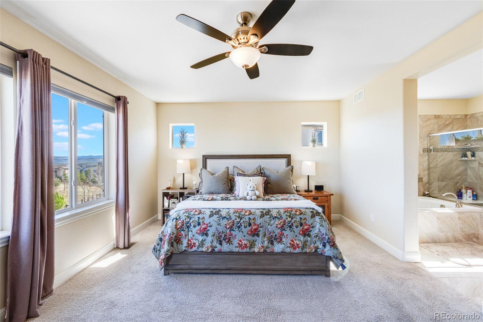 8474 Poppy Street Arvada, CO 80007 - Photo 13 of 40 a bedroom with a bed and a chandelier fan