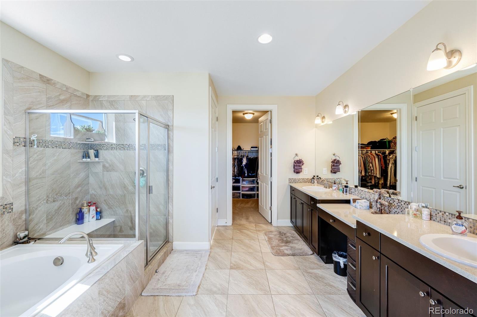 8474 Poppy Street Arvada, CO 80007 - Photo 15 of 40 a large bathroom with a tub sink shower and mirror