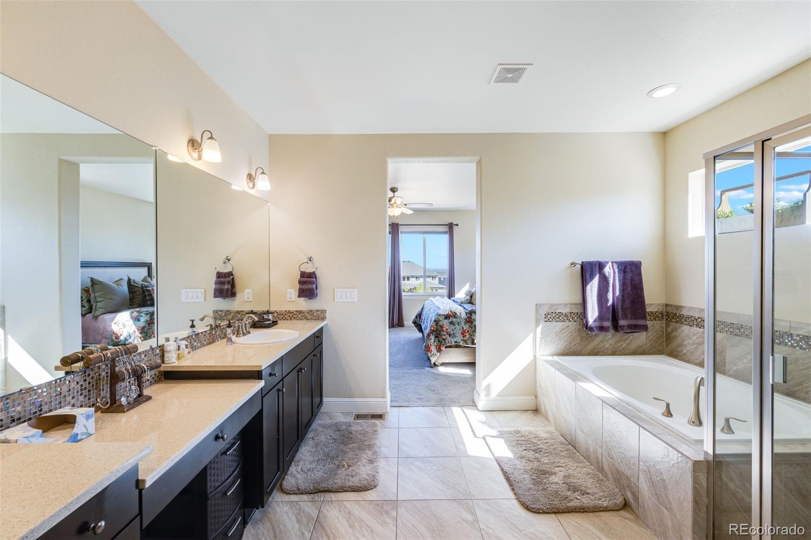 8474 Poppy Street Arvada, CO 80007 - Photo 16 of 40 a en suite bathroom with a tub double vanity and view bedroom