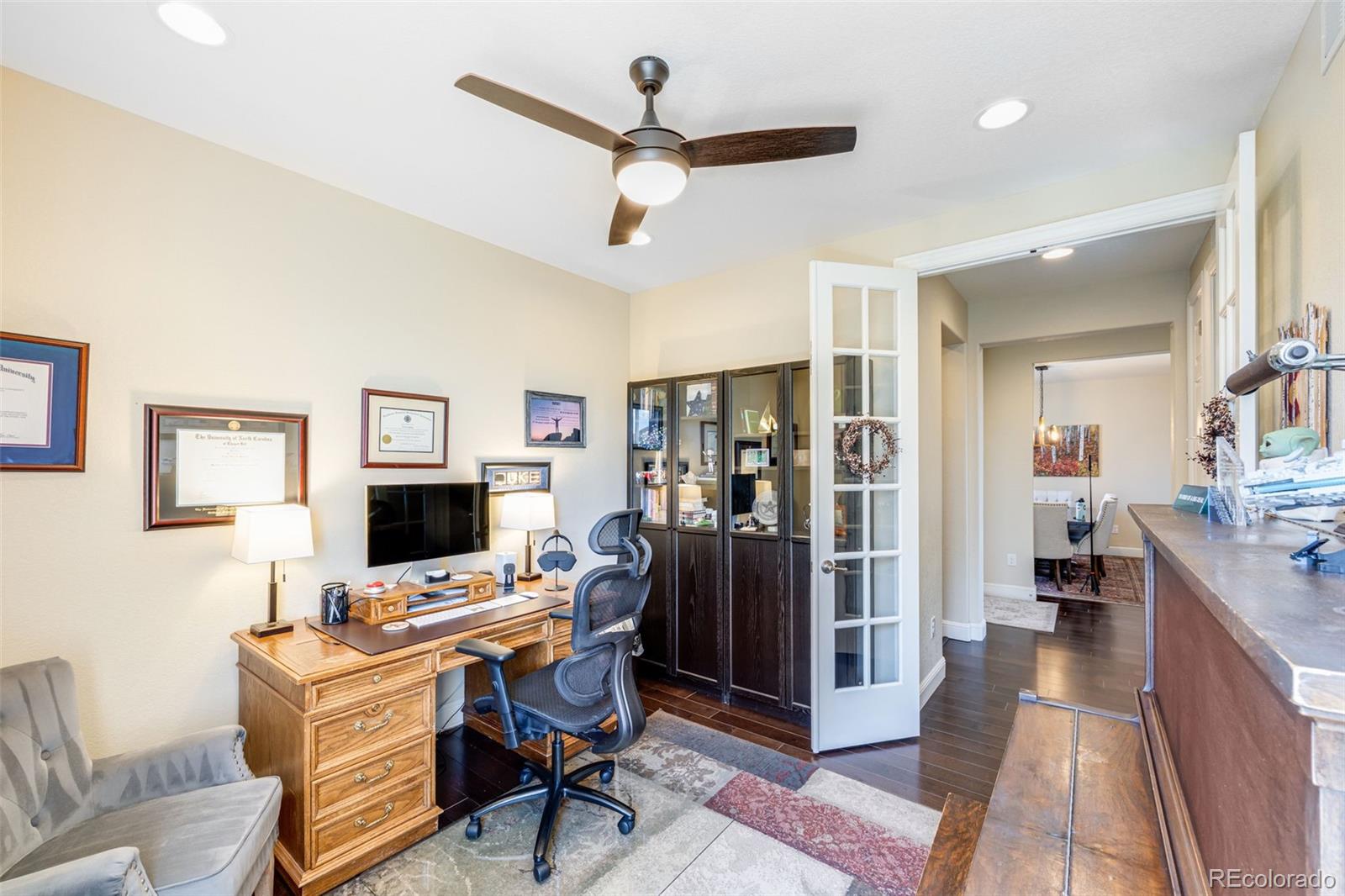 8474 Poppy Street Arvada, CO 80007 - Photo 17 of 40 a view of a workspace with furniture and a livingroom