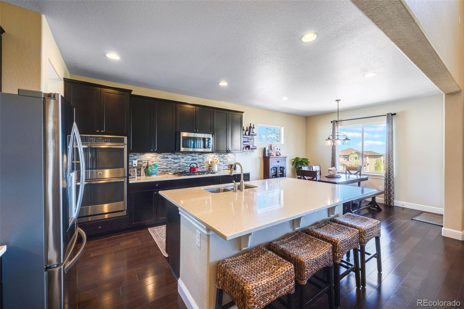 8474 Poppy Street Arvada, CO 80007 - Photo 2 of 40 a large kitchen with a table and chairs