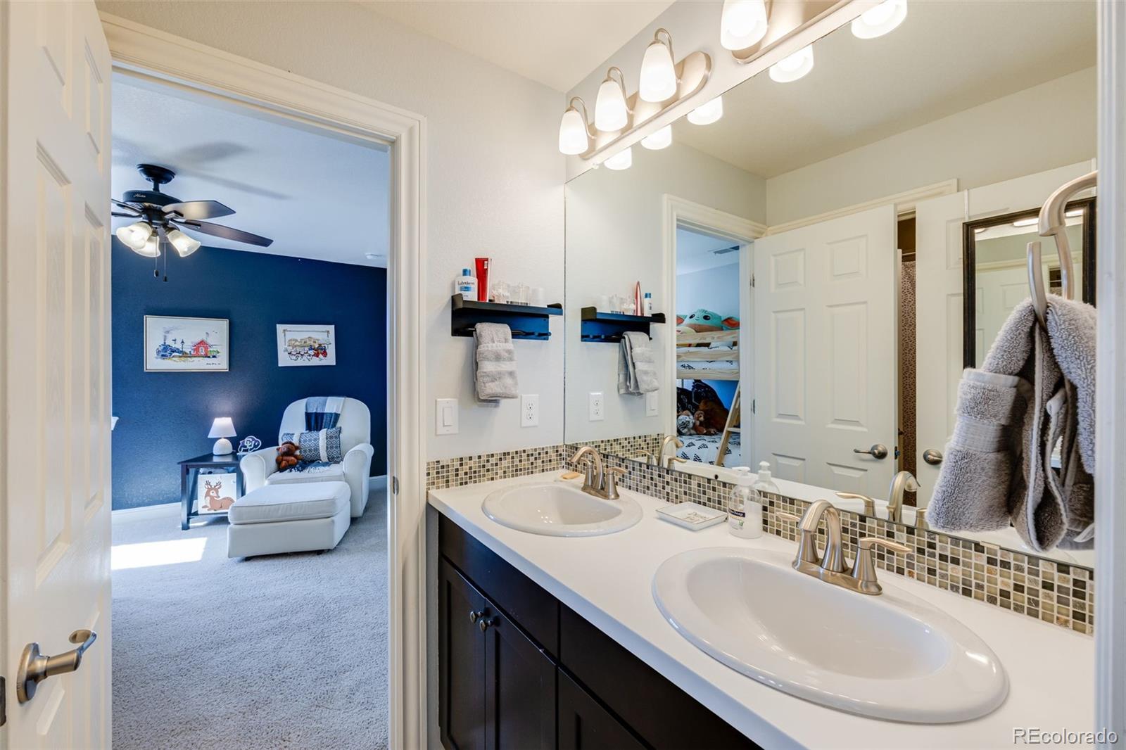 8474 Poppy Street Arvada, CO 80007 - Photo 22 of 40 a en suite bathroom with a sink double vanity and a mirror