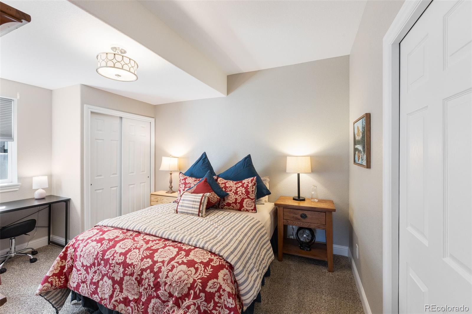 8474 Poppy Street Arvada, CO 80007 - Photo 27 of 40 a bedroom with a bed and a lamp