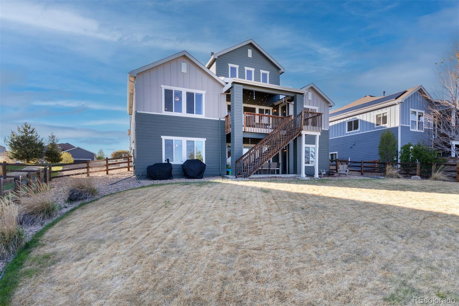 8474 Poppy Street Arvada, CO 80007 - Photo 35 of 40 a front view of a house with a yard and a garage