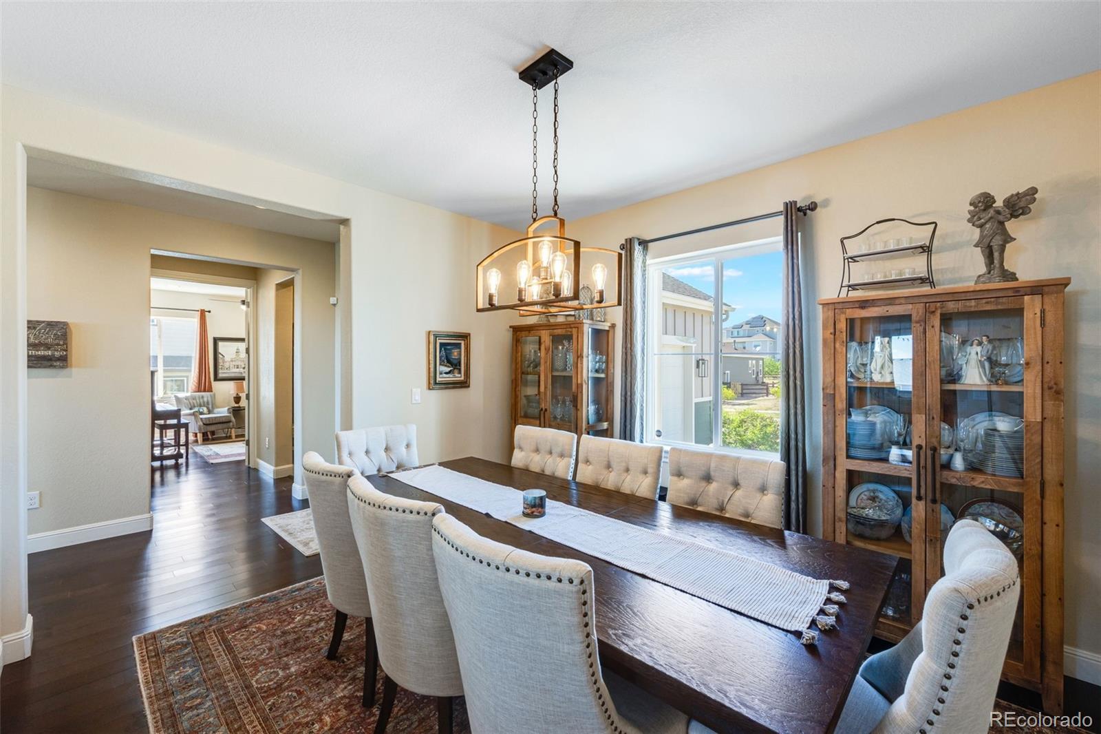 8474 Poppy Street Arvada, CO 80007 - Photo 9 of 40 a dining room with furniture wooden floor a chandelier and a rug
