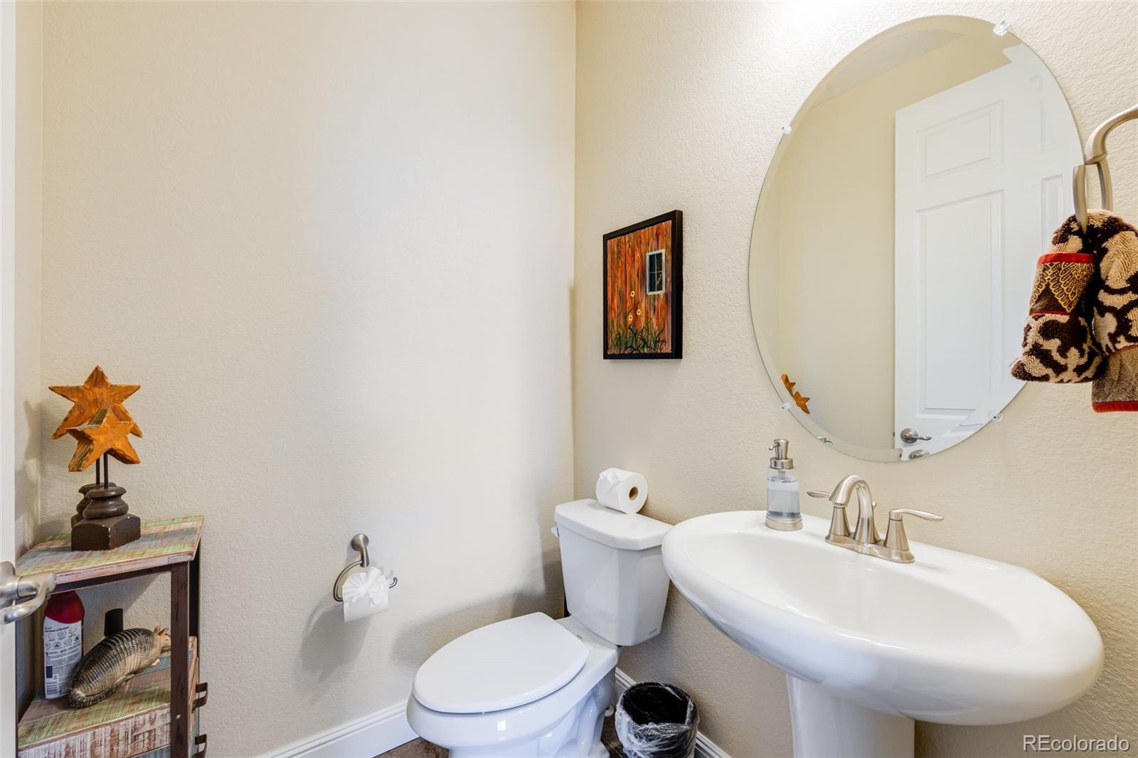 8474 Poppy Street Arvada, CO 80007 - Photo 10 of 40 a bathroom with a toilet sink and mirror