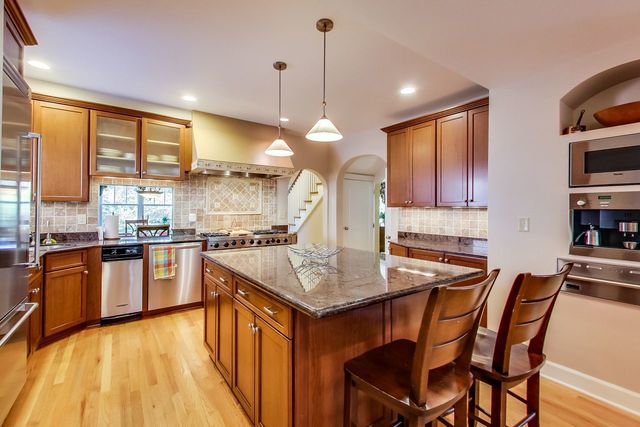 416 Wisner Street Park Ridge, IL 60068 - Photo 14 of 49 a kitchen with stainless steel appliances granite countertop a stove top oven a sink dishwasher a dining table and chairs with wooden floor