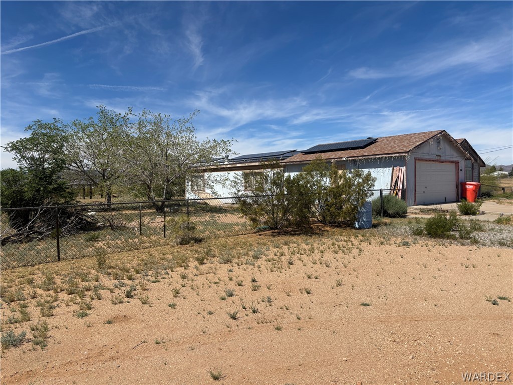 3871 Mormon Flat Road Golden Valley, AZ 86413 - Photo 8 of 52 The property features a building with a shingle roof and solar panels
