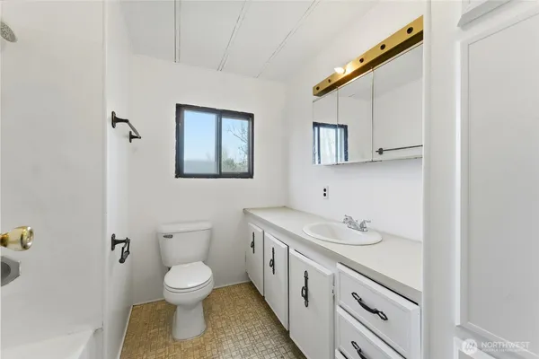 a bathroom with a toilet sink and mirror