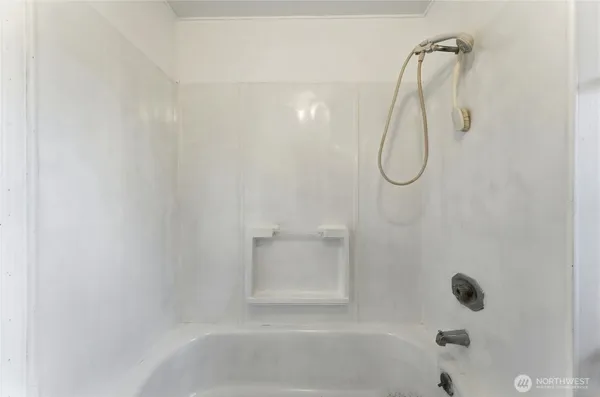 a bathroom with a bath tub with a shower
