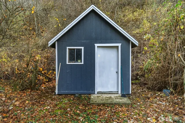 a view of a small house with yard and sitting area