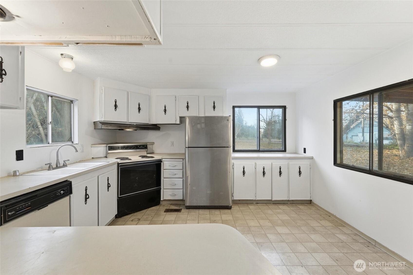 269 7 Mile Road Walla Walla, WA 99362 - Photo 8 of 40 a kitchen with stainless steel appliances granite countertop a refrigerator a stove a sink dishwasher and white cabinets with wooden floor